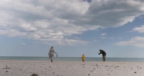 Mom, dad, boy are happy walking at the sea. Vacation, weekend, holiday concept.