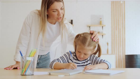 Mother and Little 6 Year Old Daughter Study Writing Letters at Home Mom Helps