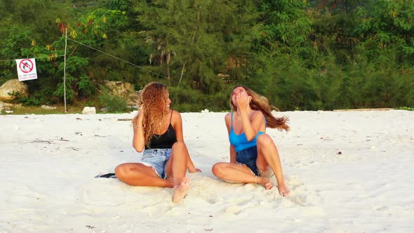 Ladies relaxing on marine shore beach adventure by blue sea with white sand background of Koh Phanga