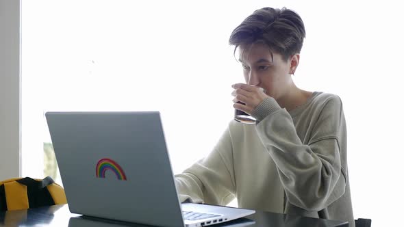 A Girl Works on a Laptop in a Cafe