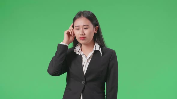 Asian Business Woman Thinking About Something Then Raising Her Index Finger On Green Screen Studio