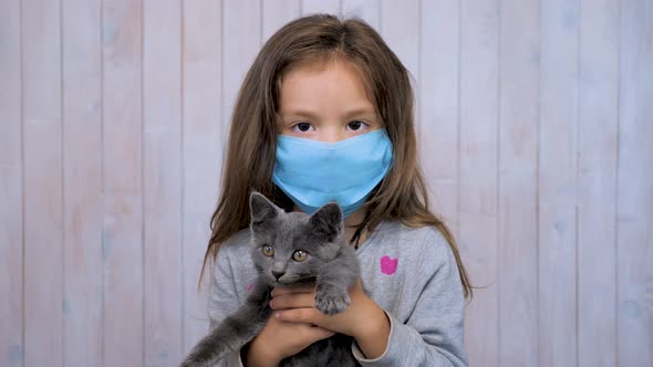 Portrait of Beautiful Brunette Teen Girl in Medical Protective Mask Over Light Gray Wall Background