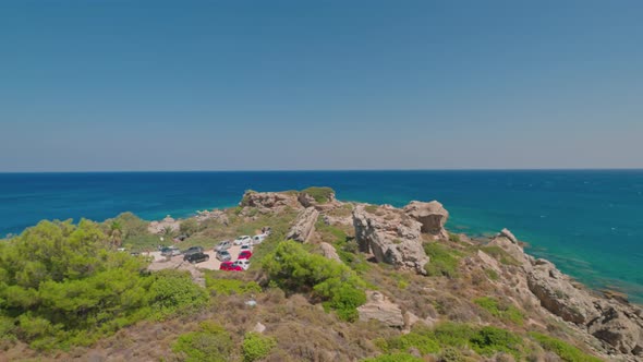 Beautiful view of rocky coast of Mediterranean Sea with equipped beaches and parking for cars.