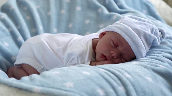 Closeup Newborn Baby Face Portrait Early Days Sleeping Sweetly On Tummy Blue Star Background