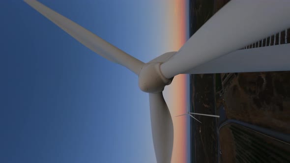 Vertical Dynamic Fpv Shot of White Operative Wind Turbine While Beautiful Sunset