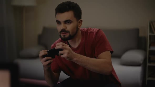 Concentrated Man Nervously Pressing Joystick Buttons, Playing Game Addiction