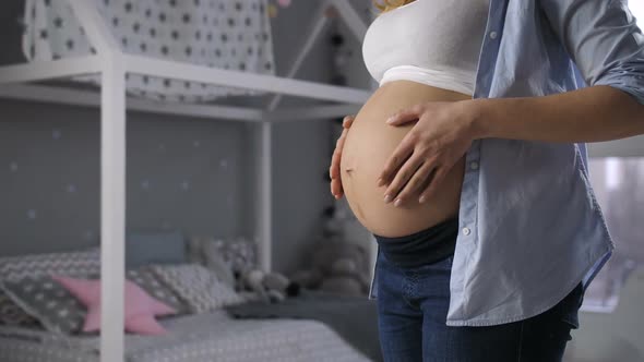 Female Hands Touching Naked Pregnant Stomach