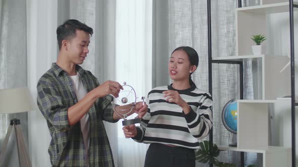 Young Asian Couple Moving Into A New House Taking Stuff Out To Decorate The Habitat Bookcase