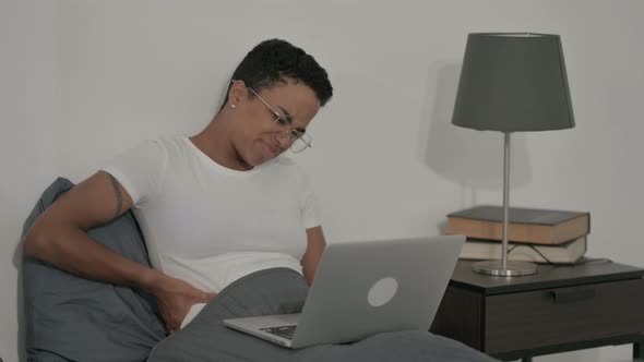 African Woman Having Back Pain While Using Laptop in Bed