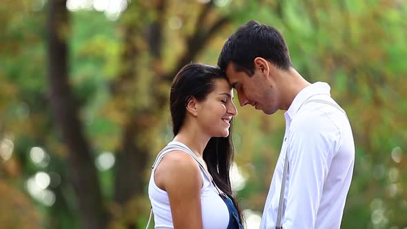 Teen couple kissing in the park in autumn time