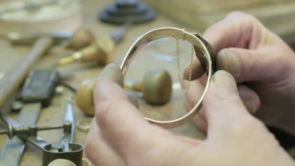 Close ups of a craftsman making jewellery in a workshop.