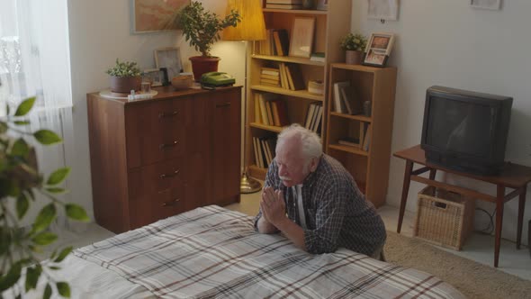 Older Man Praying by Bed