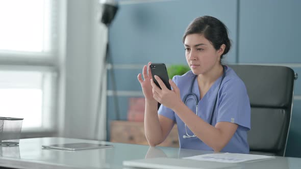 Indian Female Doctor using Smartphone in Office
