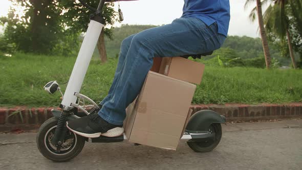 Delivery Asian Man Rides A Electric Scooter On The Road To Deliver Orders And Packages For Customers