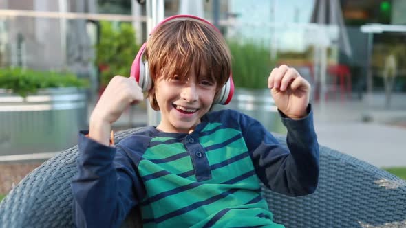 A young boy with headphones on listens to and dances to his favorite songs.
