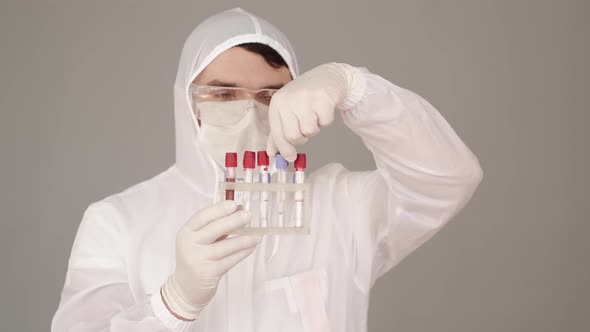 Male Researcher in Special Equipment Is Examining Blood Tests