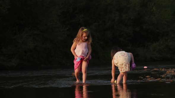 Two girls playing with paper boats