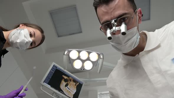 First-person view, dentist and assistant working with a patient.