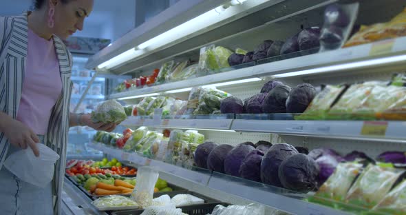 Young Woman in a the Grocery Department of a Supermarket Is Buying Up Food Concept Where People Are