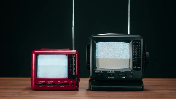 Small Old Televisions with Grey Interference Screen on Black Background