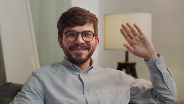 European Happy Man Looks at the Camera and Waves His Hand