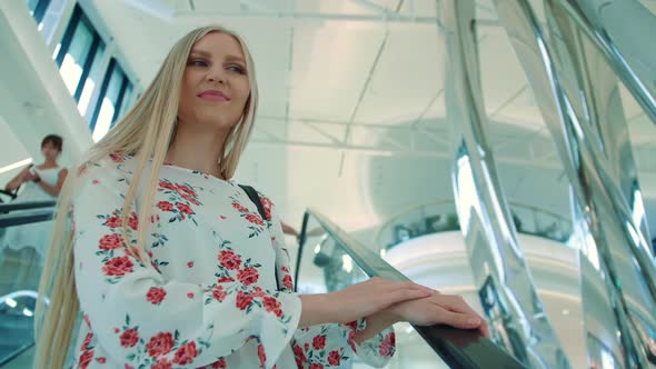 Woman Riding Escalator in Mall