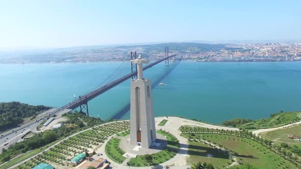 Aerial view of Sanctuary of Christ the King overlooking Lisbon and 25 de Abril Bridge connecting Lis