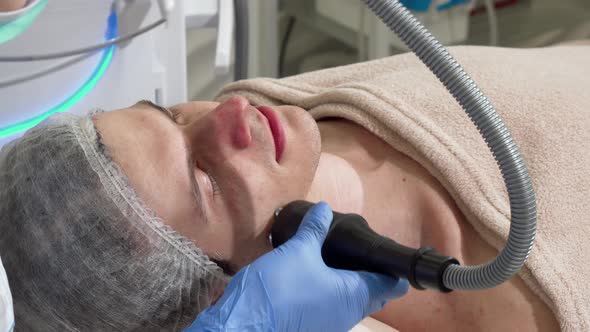 Handsome Man Getting Rf-lifting Treatment By Cosmetologist