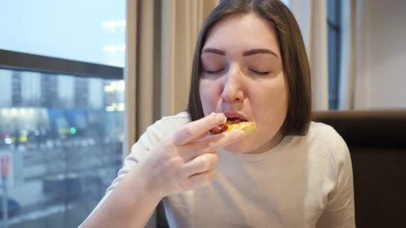 Young Woman Eating Bruschetta with Cheese and Tomatoes