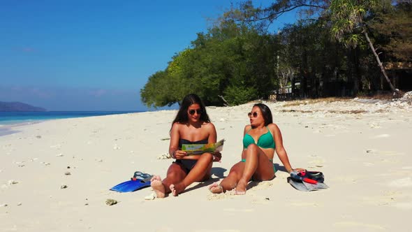 Ladies best friends on beautiful bay beach adventure by blue sea and white sandy background of Gili 