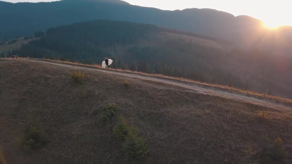 Newlyweds Dancing on a High Slope of the Mountain. Groom and Bride. Aerial View