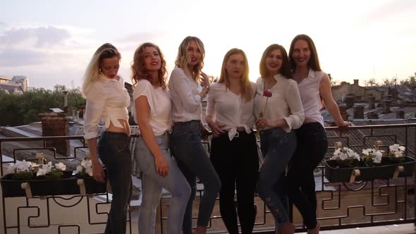 Six Caucasian Girls are Standing on a Balcony and Posing for the Camera