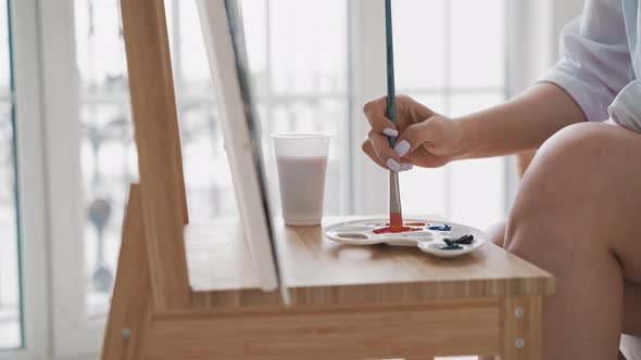 Woman Artist Draws Taking Paint From Palette with Brush