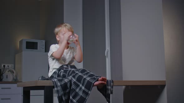 Little Boy Have Late Supper in Modern Kitchen