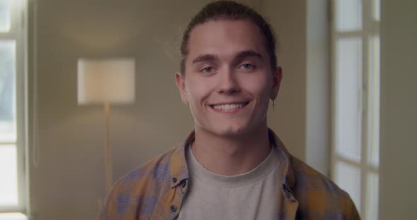 Headshot Portrait of Attractive Confident Caucasian Man Looking at Camera Standing at Modern Living