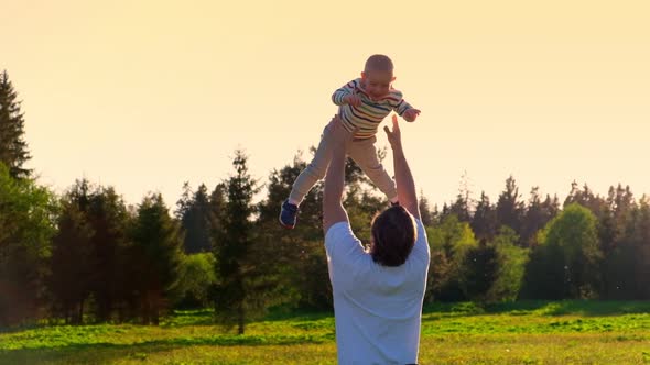 Father and Son Playing Outdoors at the Sunset Time