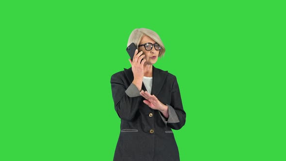 Stylish Focused Busy Greyhaired Lady Ceo Boss Chief Calling on a Green Screen Chroma Key