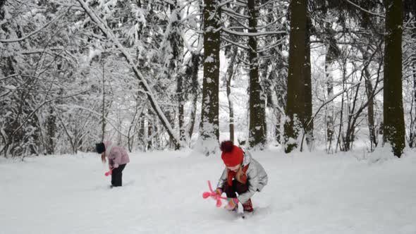 Two Little Sisters Playing Snowballs