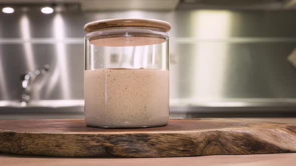 Sourdough Starter In A Glass Jar With Bubbles Rising - slider up, time lapse