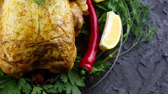 Fried Chicken Lies in a Plate with Parsley Dill and Red Pepper