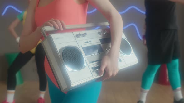 Aerobics Instructor Holding Retro Stereo