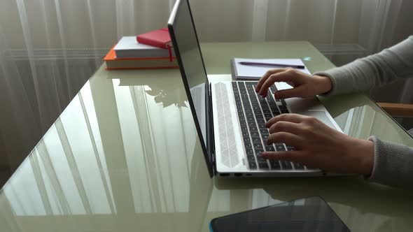 The girl working at home office hands on keyboard