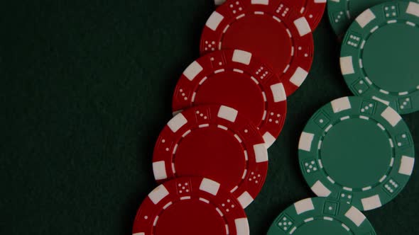 Rotating shot of poker cards and poker chips on a green felt surface - POKER 047