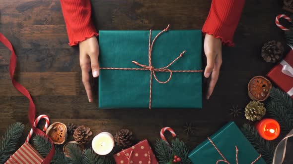 Christmas gift box given by a woman on the table with beautiful decorating items