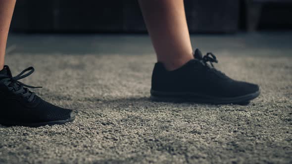 Woman Walking on Carpet and Stop in Front of Camera. Detail of Woman Feet Wearing Sport Shoes