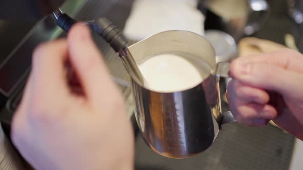 the Hands of the Barista Steamed the Milk Into a Thick Foam in the Pitcher and Rubbed the Tip of the