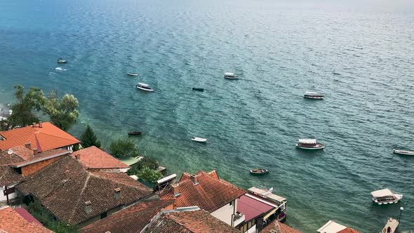 roofs of houses on shore and group boats