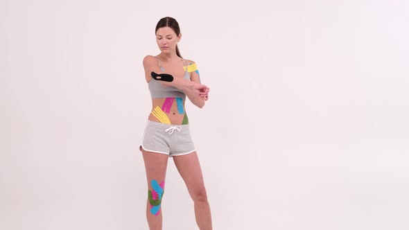 Young fit women showing on her elbow applied elastic kinetic tape, Kinesiology physical therapy