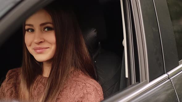 Young woman in car. Auto as present or gift at birthday.