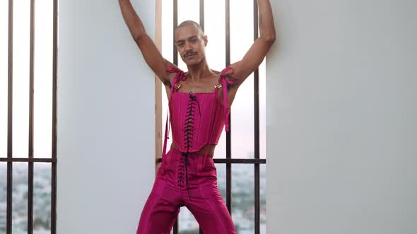 Dancing Male in Pink Bodice Against Barred Window